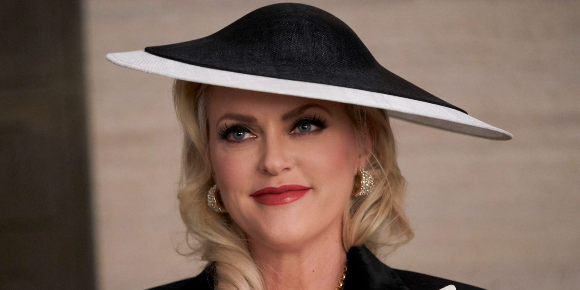 Elaine Hendrix as Alexis from Dynasty wearing a wide-brimmed hat.