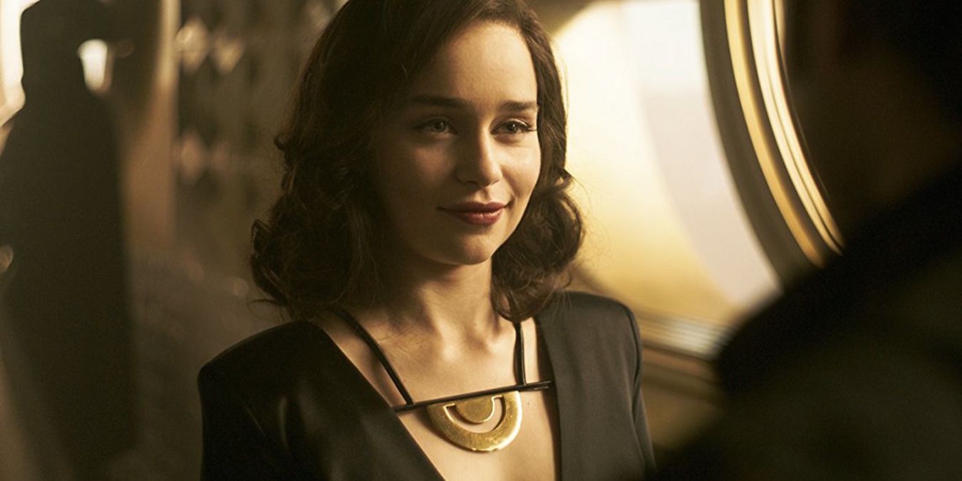 Emilia Clarke as Qi'ra, talking to Solo at the social event
