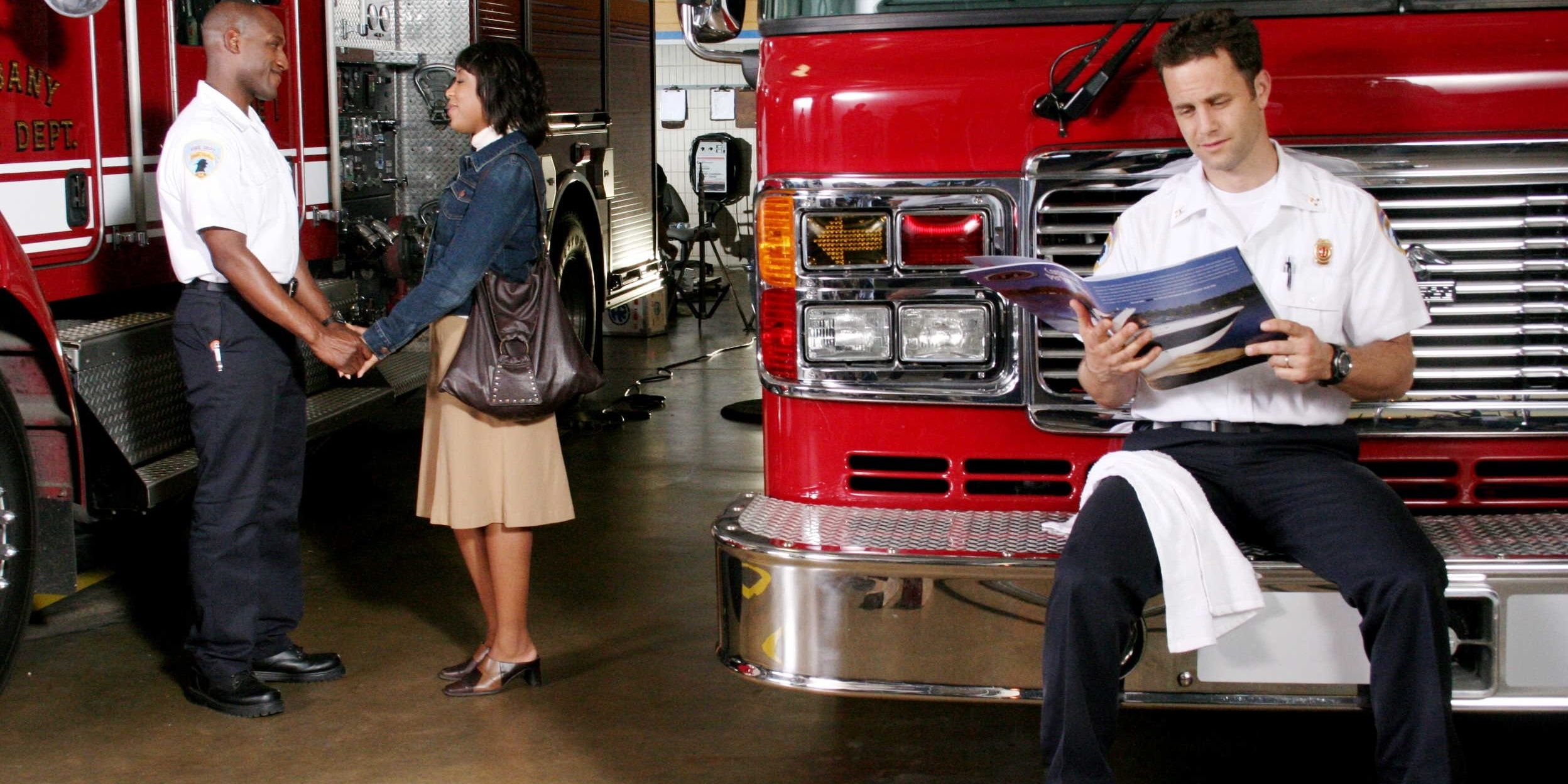 Kirk Camera reads a book on the front of a fire engine, a couple holds hands next to him in Fireproof.