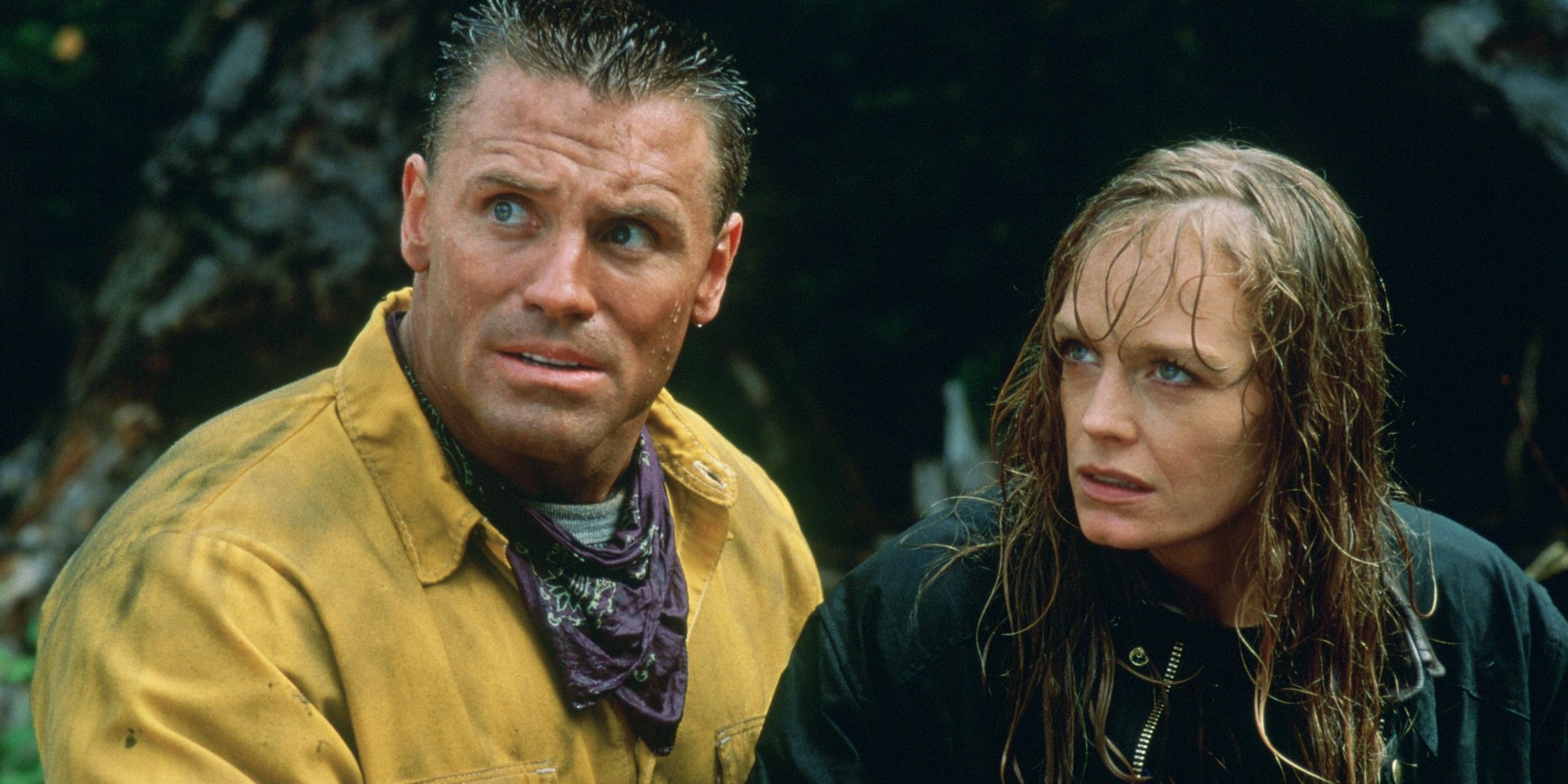Howie Long and Suzy Amis looking off camera in the forest in Firestorm.