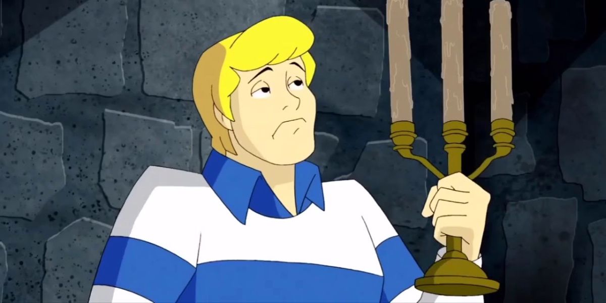 Fred with a frown while holding candle opera in Scooby-Doo