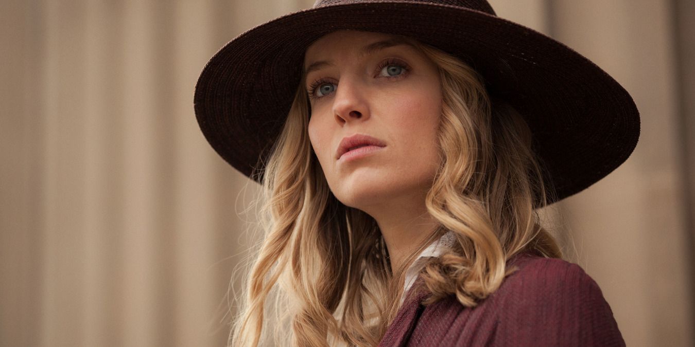 Grace standing in her purple jacket and sun hat