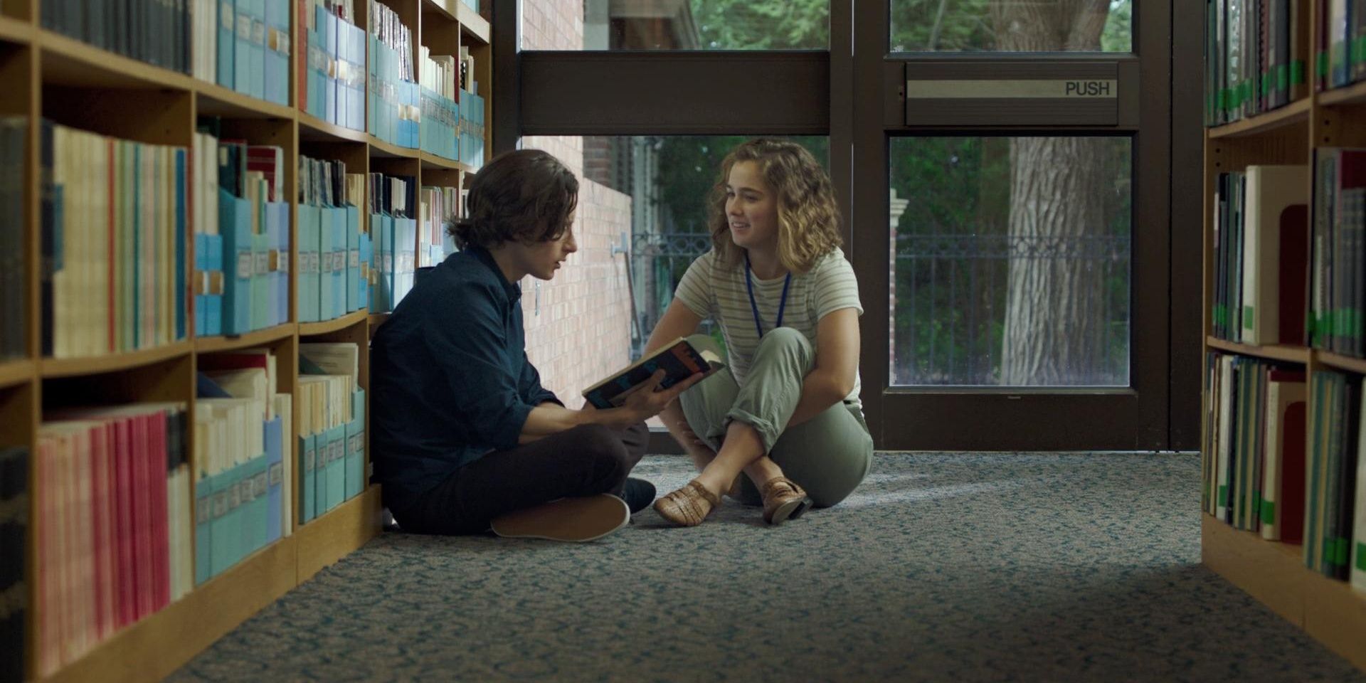 Haley Lu Richardson and Rory Culkin talking while sitting on the floor in the library in Columbus 2017