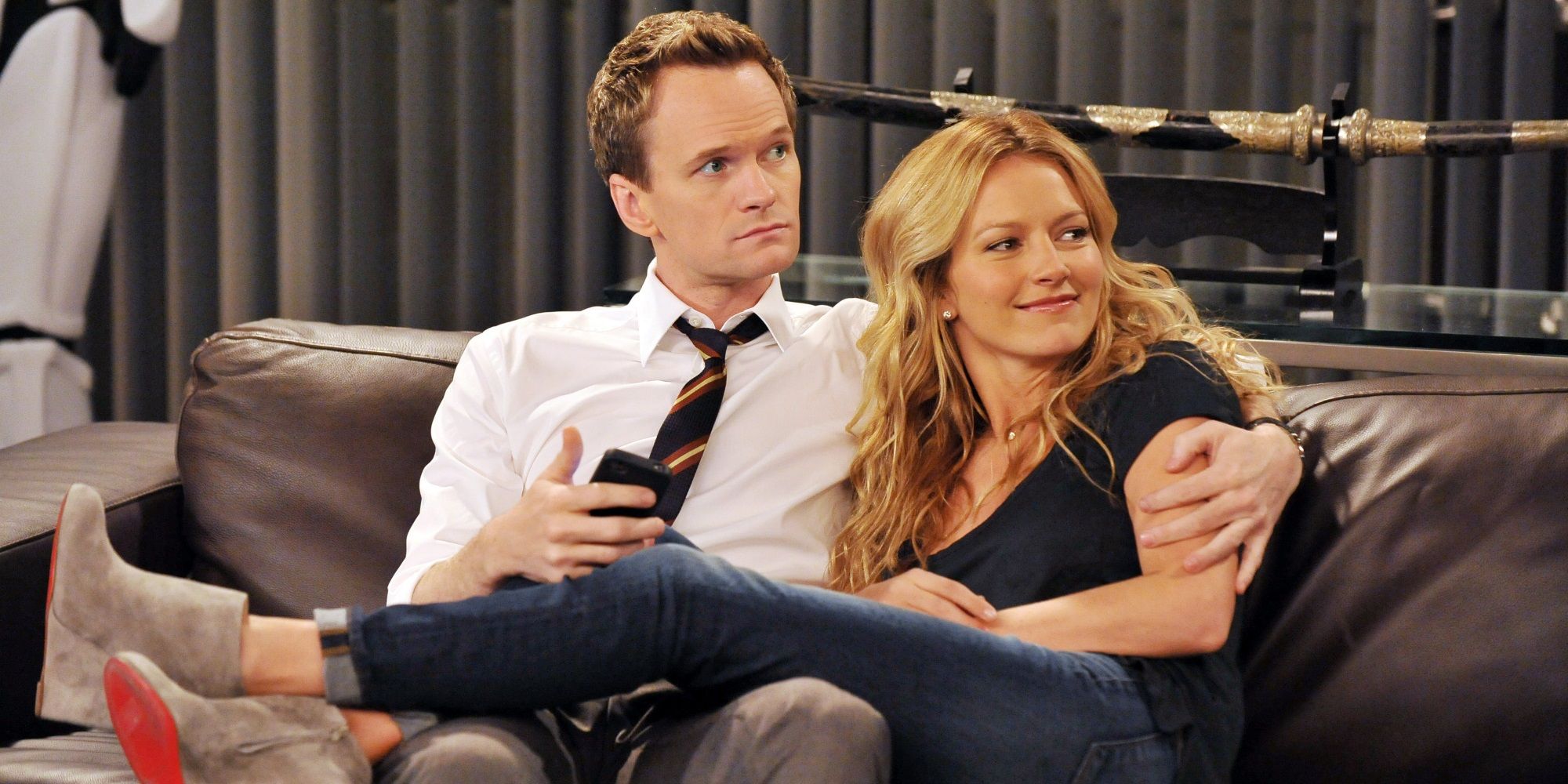Barney and Quinn sitting on the couch in How I Met Your Mother.