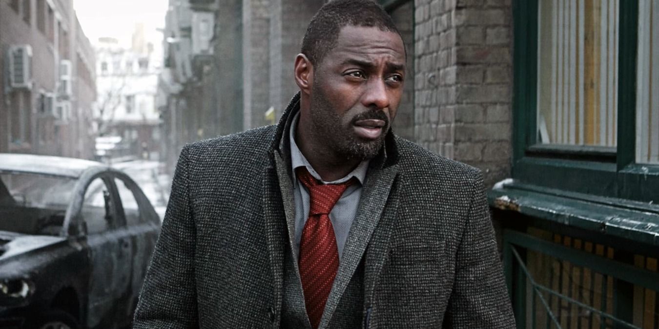 Idris Elba as Luther walking down a street in a suit jacket