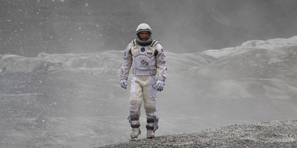 Cooper walking in a desolate landscape in Interstellar