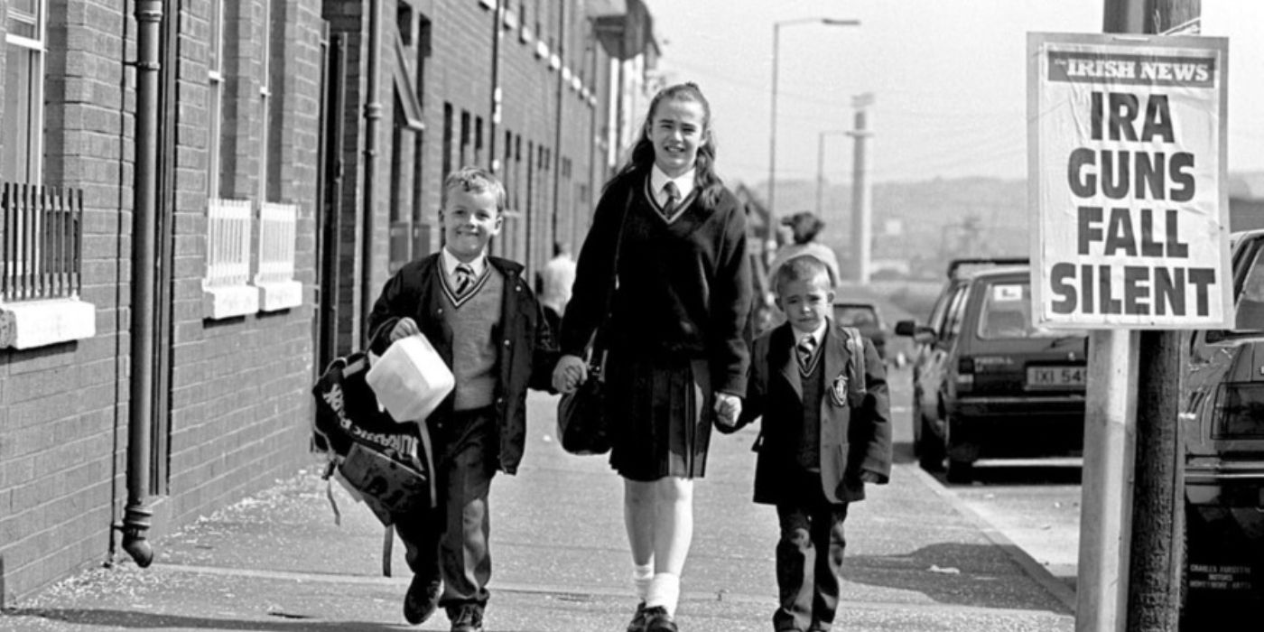 Irish school children walking while a poster announces the 1994 IRA ceasefire