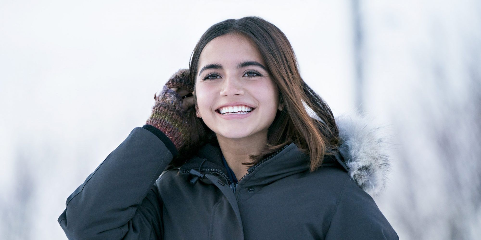 Julie (Isabela Merced) smiling outside in the snow in Let It Snow 