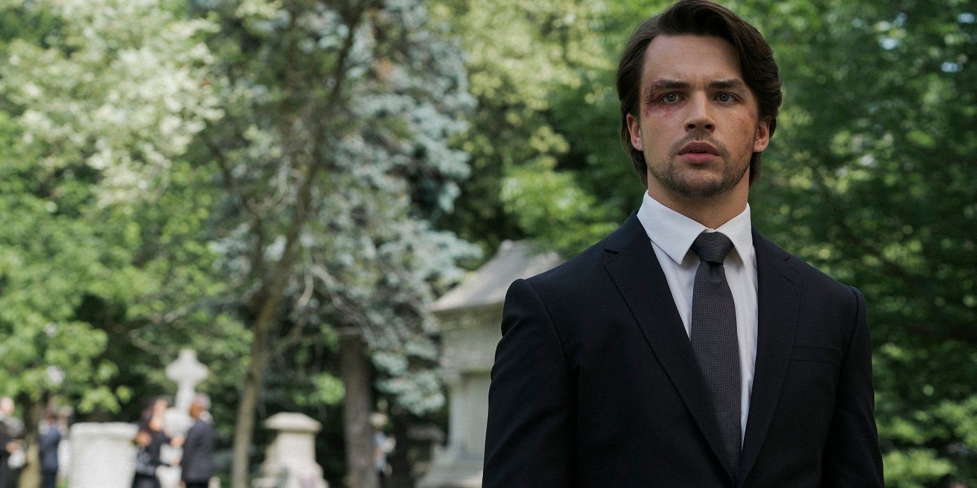 Brandon Sampson, in a suit and tie, stands in a cemetery in the Netflx show Jupiter's Legacy.