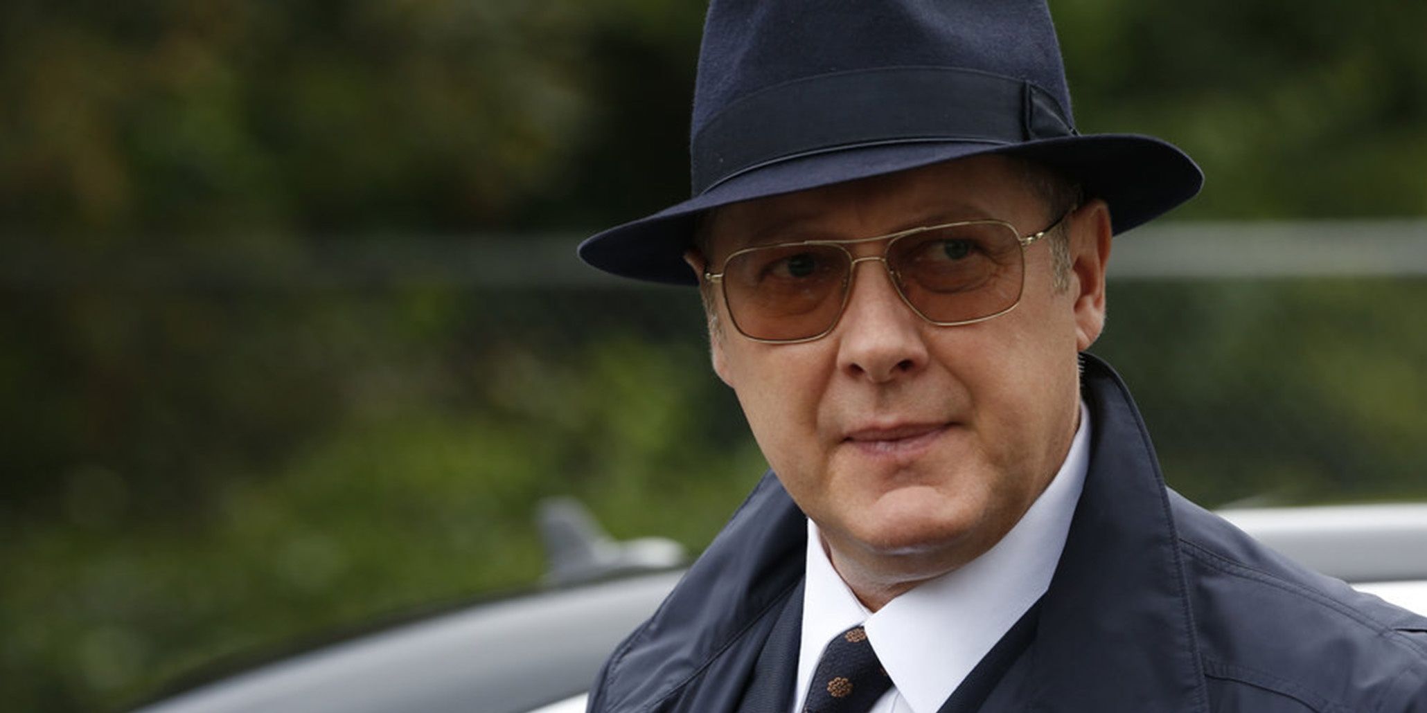 James Spader as Raymond 'Red' Reddington in The Blacklist wearing a top hat and sunglasses