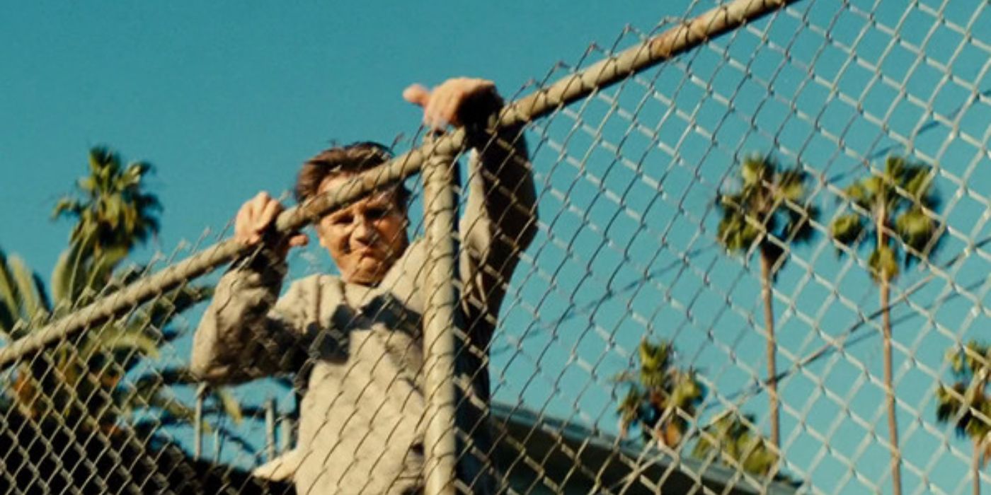 Liam Neeson climbing a fence in Taken 3