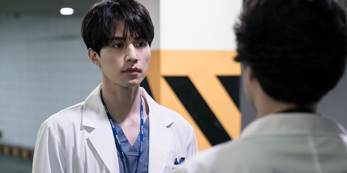 Jin-Woo vestindo jaleco de médico encarando alguém na vida 