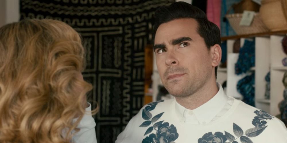 David pursing his lips and looking upwards while he talks to Joselyn in Schitt's Creek