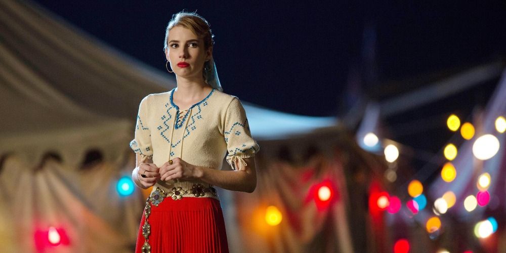 Maggie standing in front of a tent full of lights in a scene from Freak Show