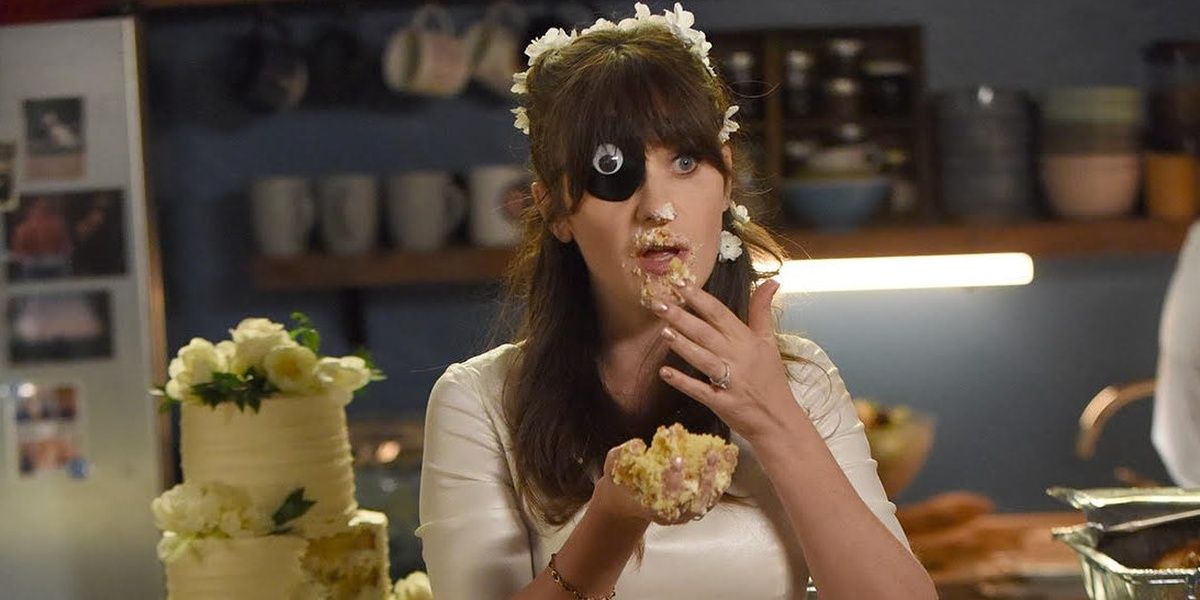 Jess in her wedding dress, with an eyepatch, eating cake in New Girl