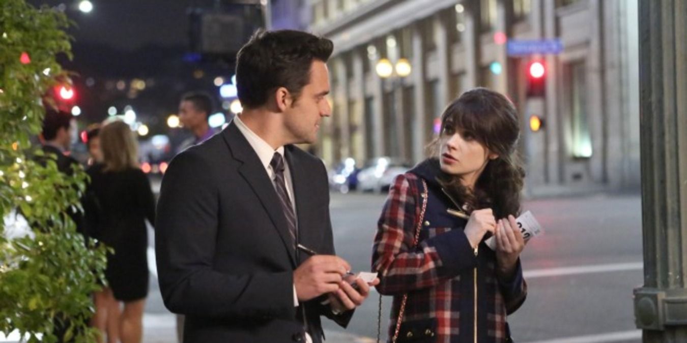 Nick and Jess with their paper, standing on the street in New Girl