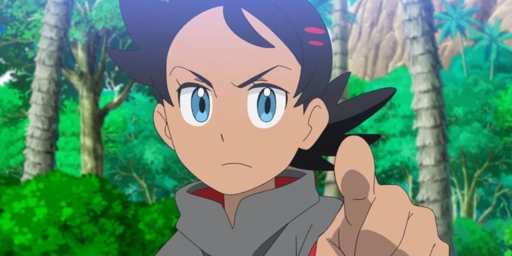 Goh from Pokémon pointing their finger at an opponent and frowning.