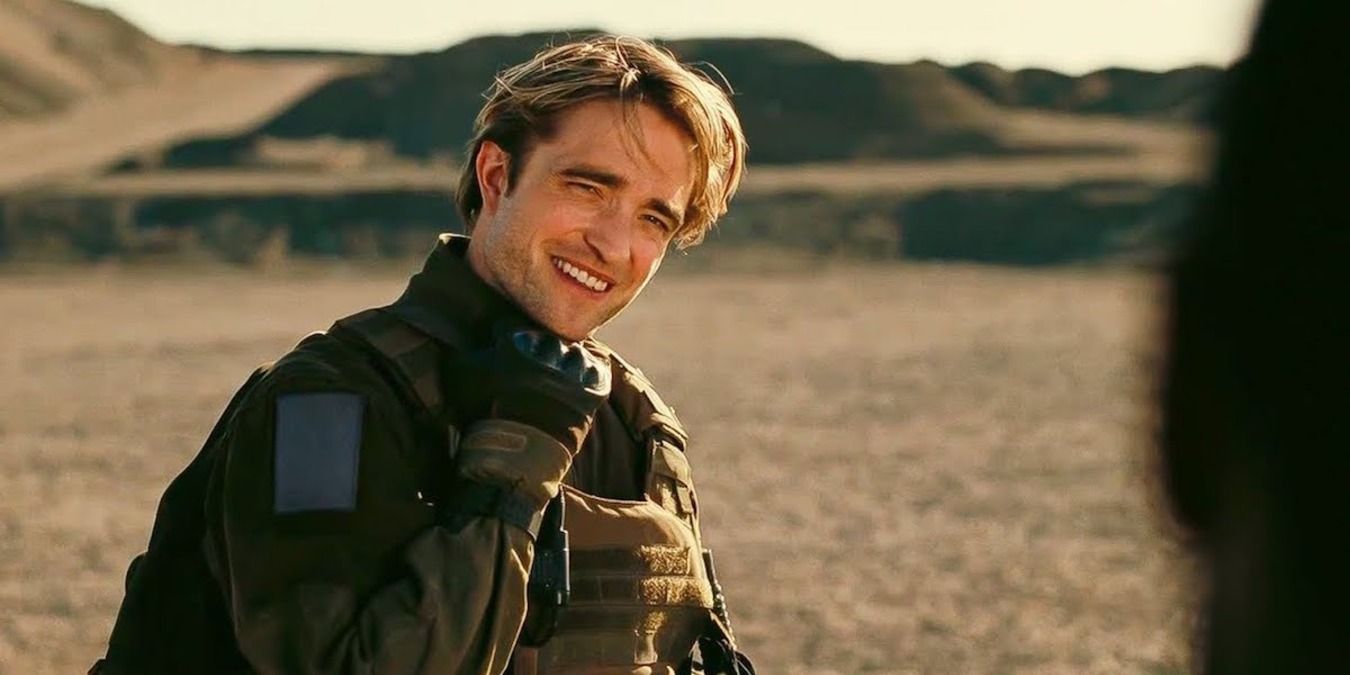 Robert Pattinson as Neil, standining in the open field in full gear in Tenet