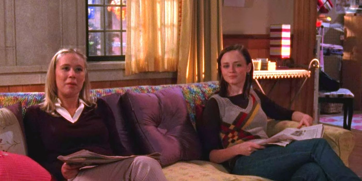 Rory and Paris sitting on their dorm room couch on Gilmore Girls