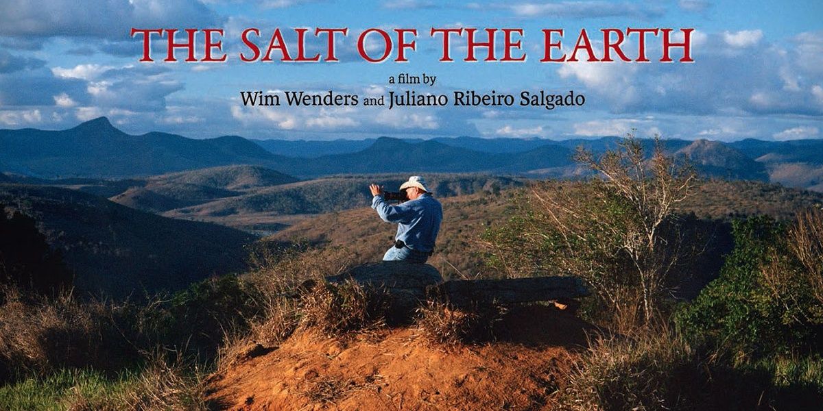 Sebastiao Salgado clicking a photograph sitting atop a cliff in a poster for The Salt of the Earth 