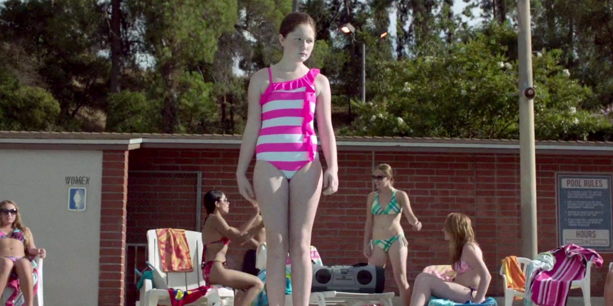 Debbie stands at the edge of the swimming pool in Shameless