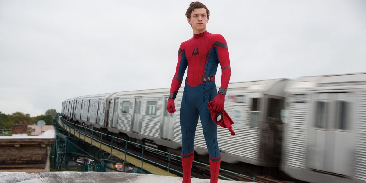 Spider-Man standing next to train tracks