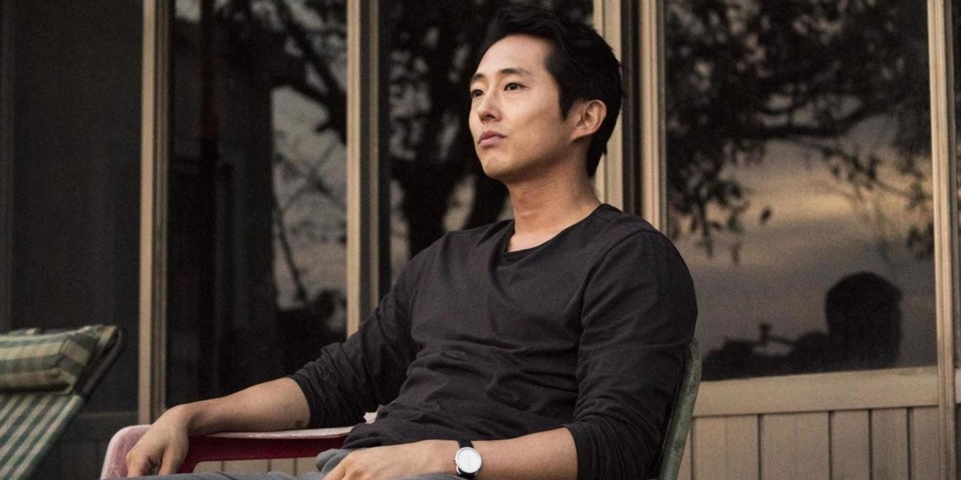 Steven Yeun as Ben, sitting outside in a lawn chair in Burning