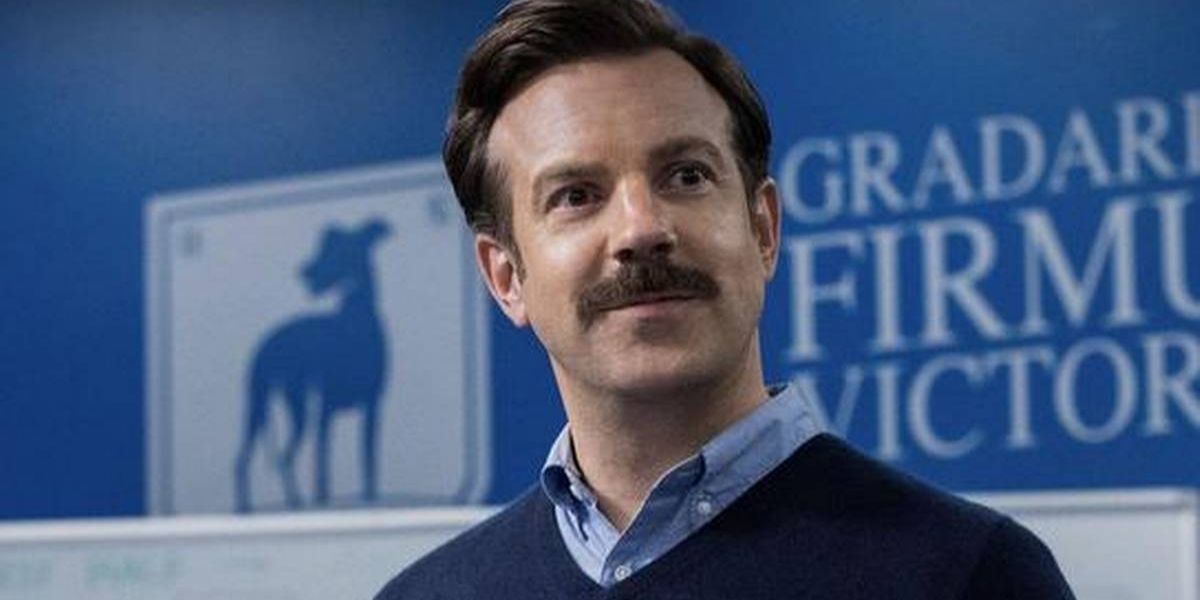 Jason Sudeikis as Ted Lasso standing on the side line of the pitch