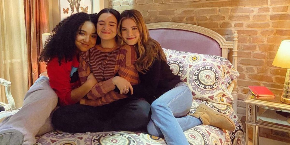 Kat, Jane, and Sutton hugging on Jane's bed