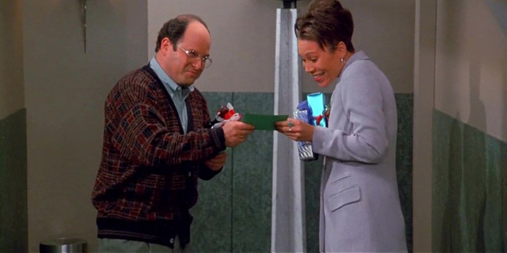 George passando um presente de Natal para um colega de trabalho em Seinfeld.