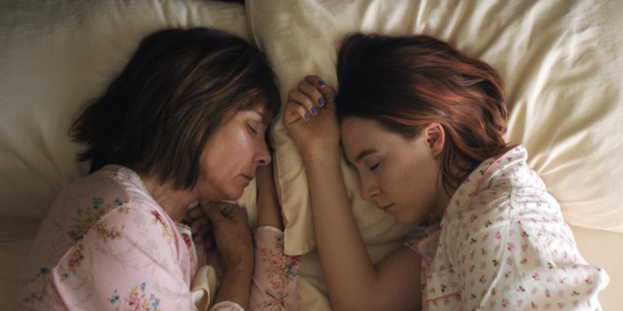 Lady Bird and her mom lying on a bed together sleeping