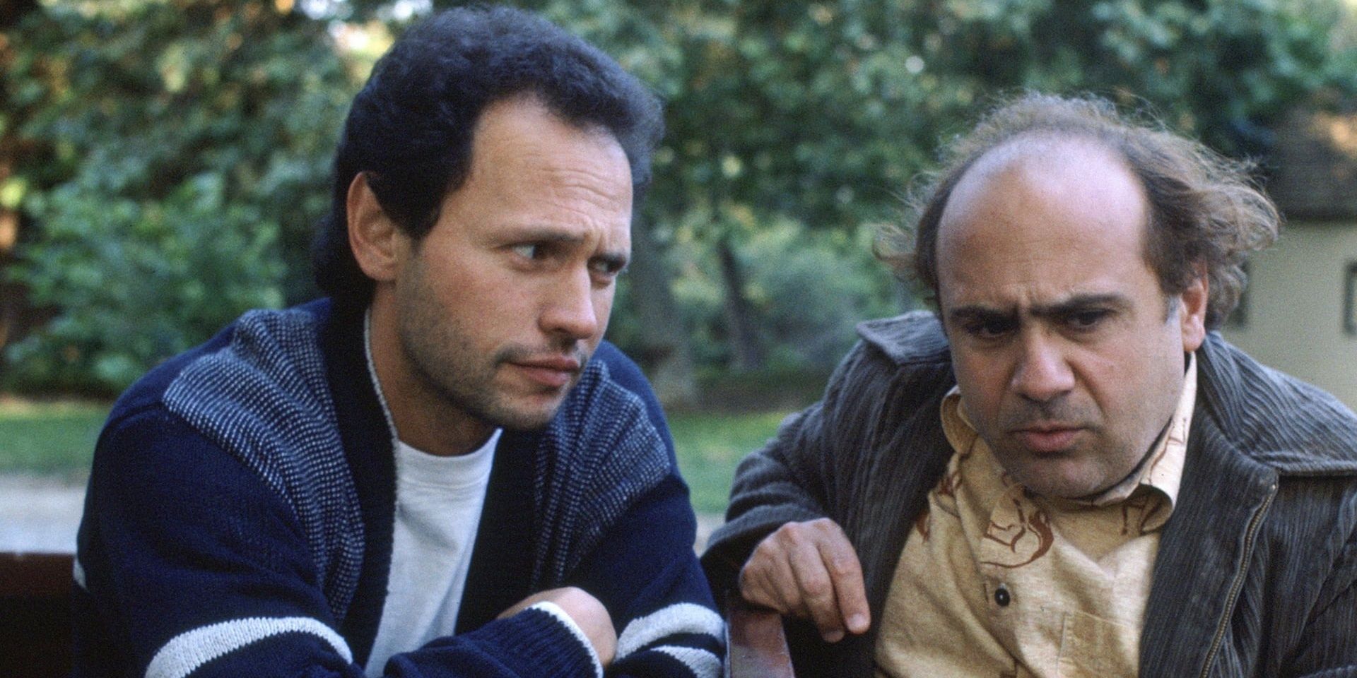 Billy Crystal talking to Danny Devito sitting at a table in Throw in Momma From The Train