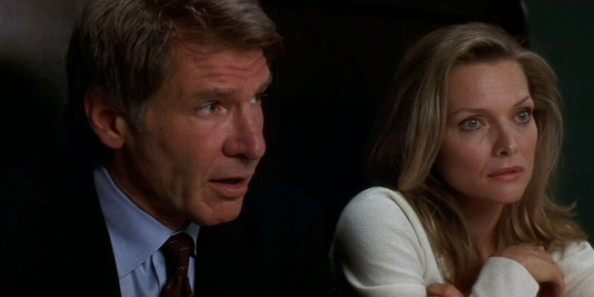 Harrison Ford y Michelle Pfeiffer en un restaurante hablando con alguien fuera de cámara en What Lies Beneath
