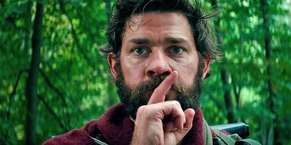 John Krasinski holding his finger up to his lips in A Quiet Place