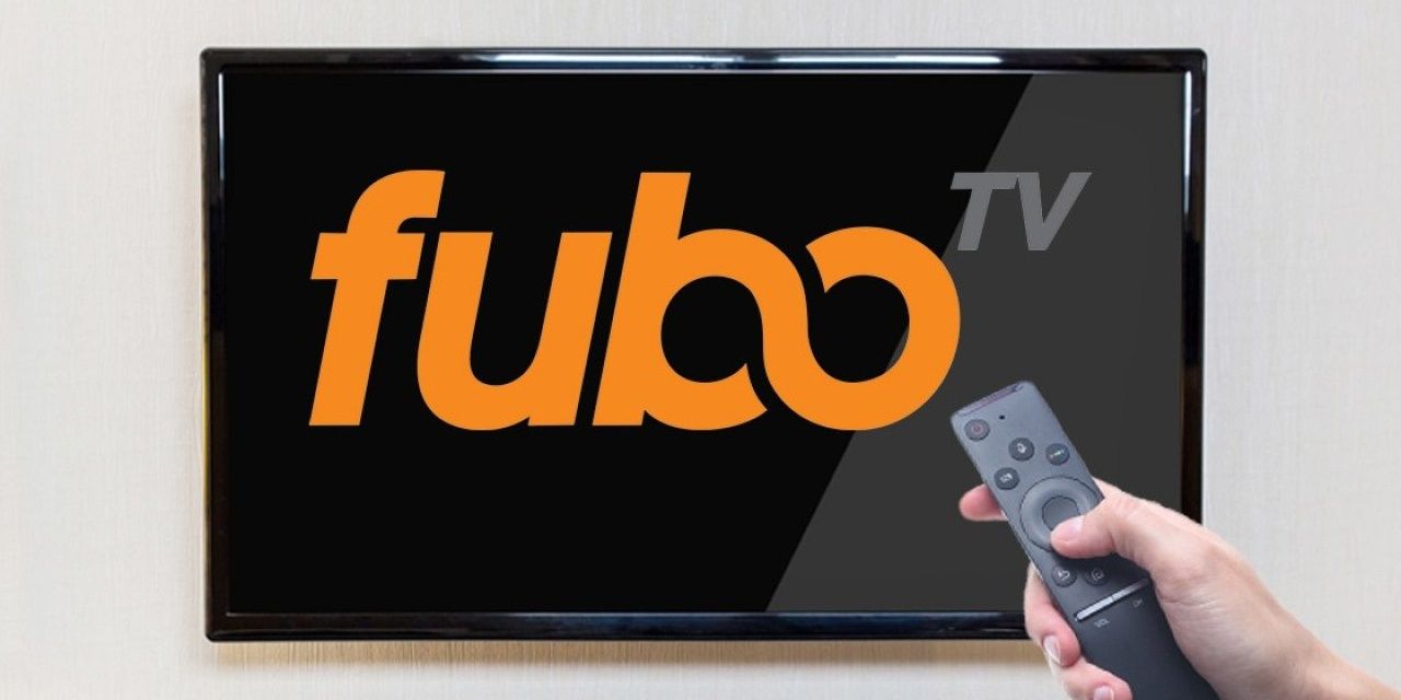 Hand holding a remote and pointing at Fubo TV