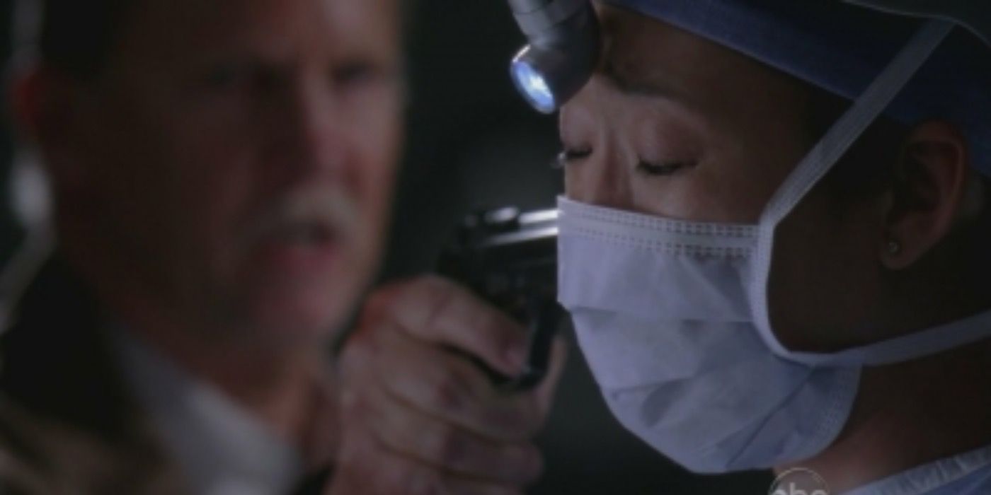 Cristina operating on Derek with a gun pointed at her in Grey's Anatomy.
