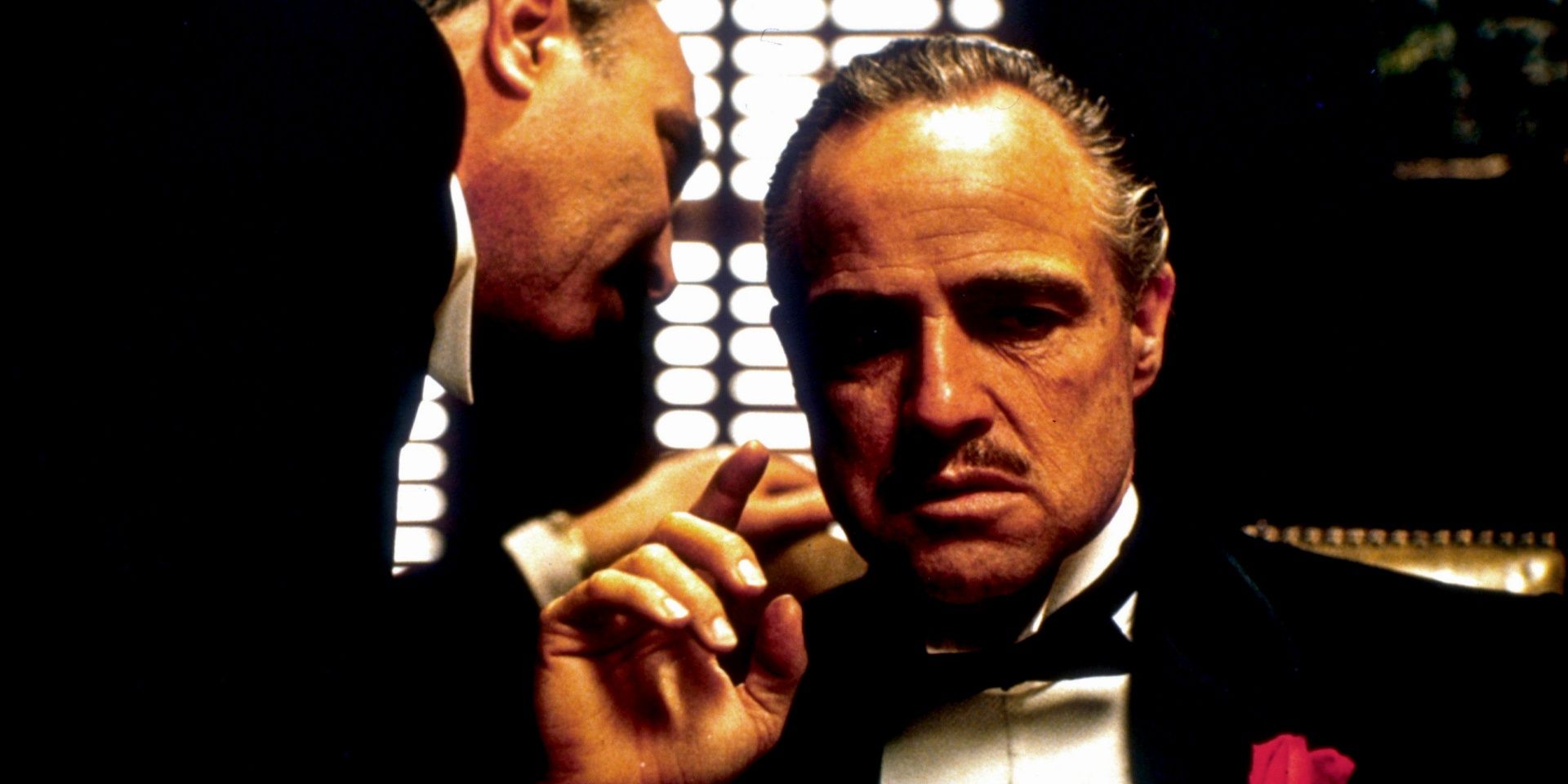 iconic scene from The Godfather depicting Bonasera whispering into the ears of Vito Corleone