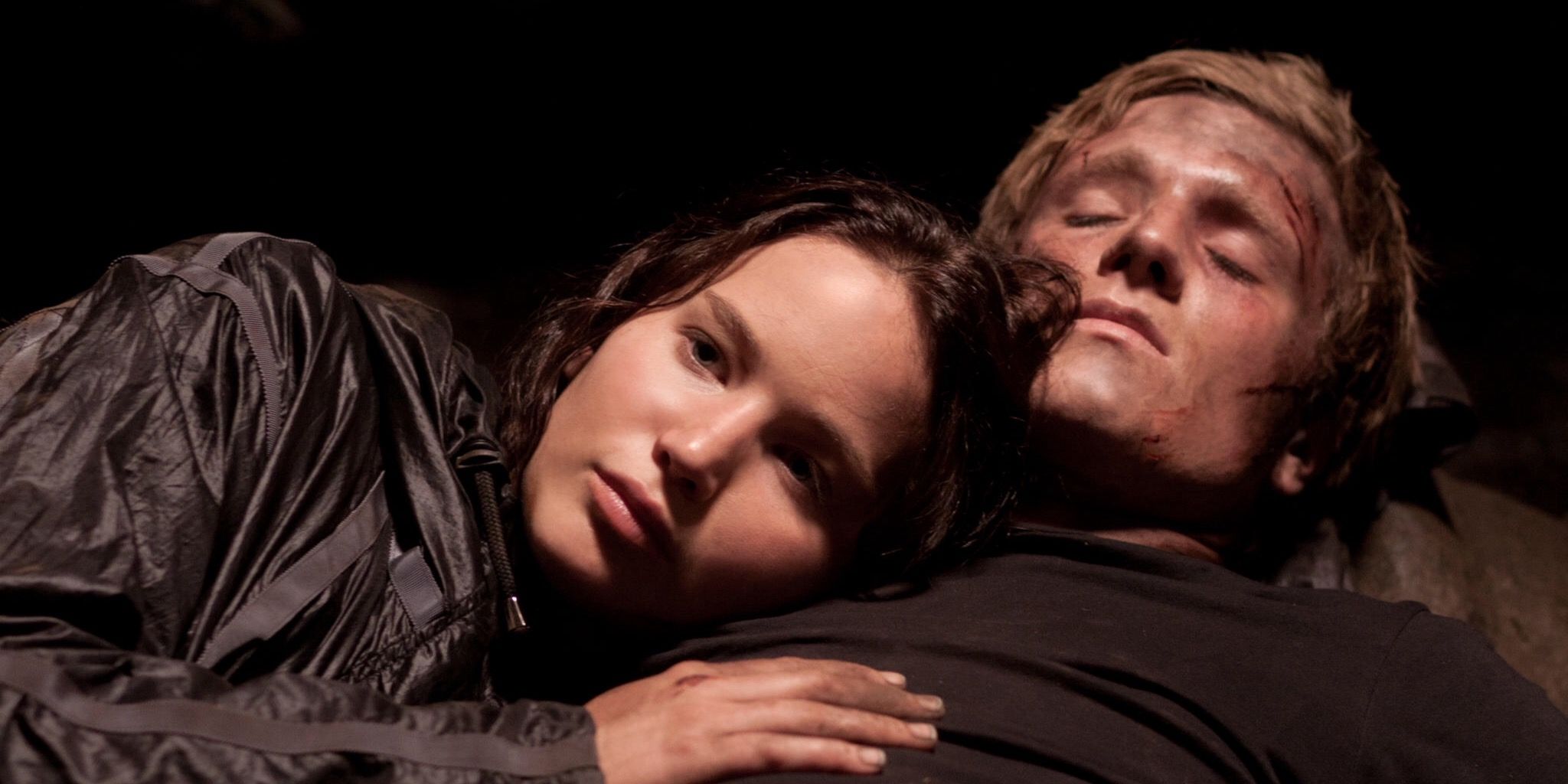 Katniss lies with Peeta in cave in Hunger Games
