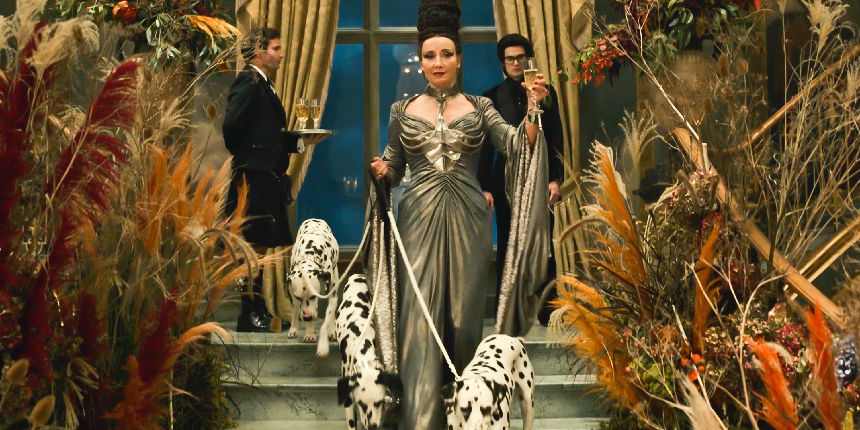 The Baroness by Emma Thompson walking Dalmatians down staircase in Cruella 2021