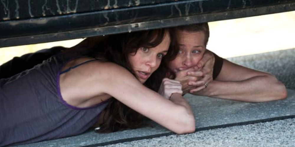Lori and Carol hide from walkers underneath a car