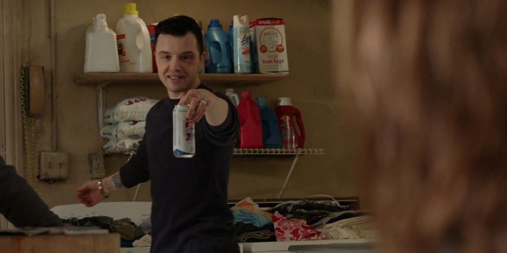Mickey holds up beer and points in Shameless