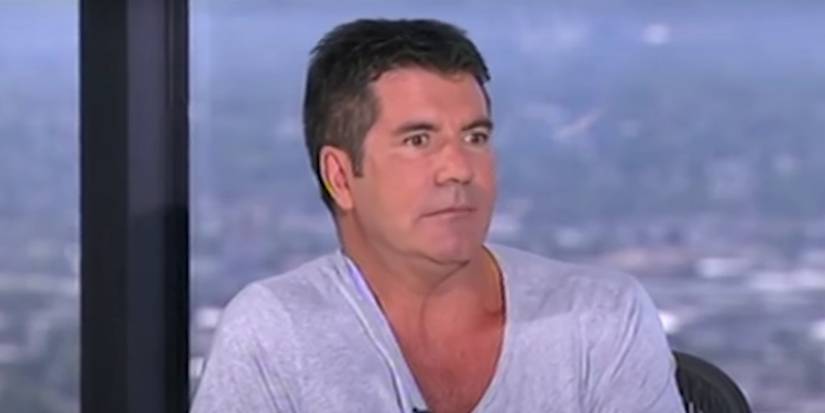 simon cowell cringing on american idol in a blue t-shirt during auditions