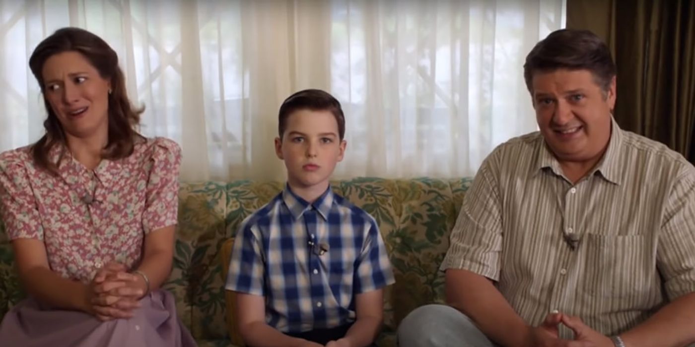 Sheldon, Mary e George Sr. sentados no sofá em Young Sheldon