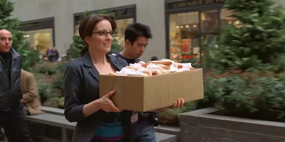 Liz Lemon carries a box of hot dogs in 30 Rock