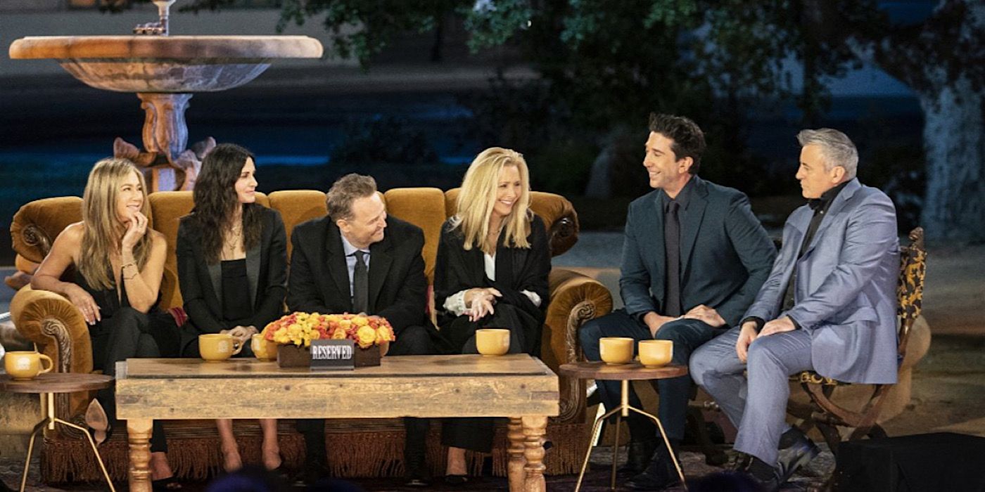 The six main cast members of Friends sitting on the orange couch and talking