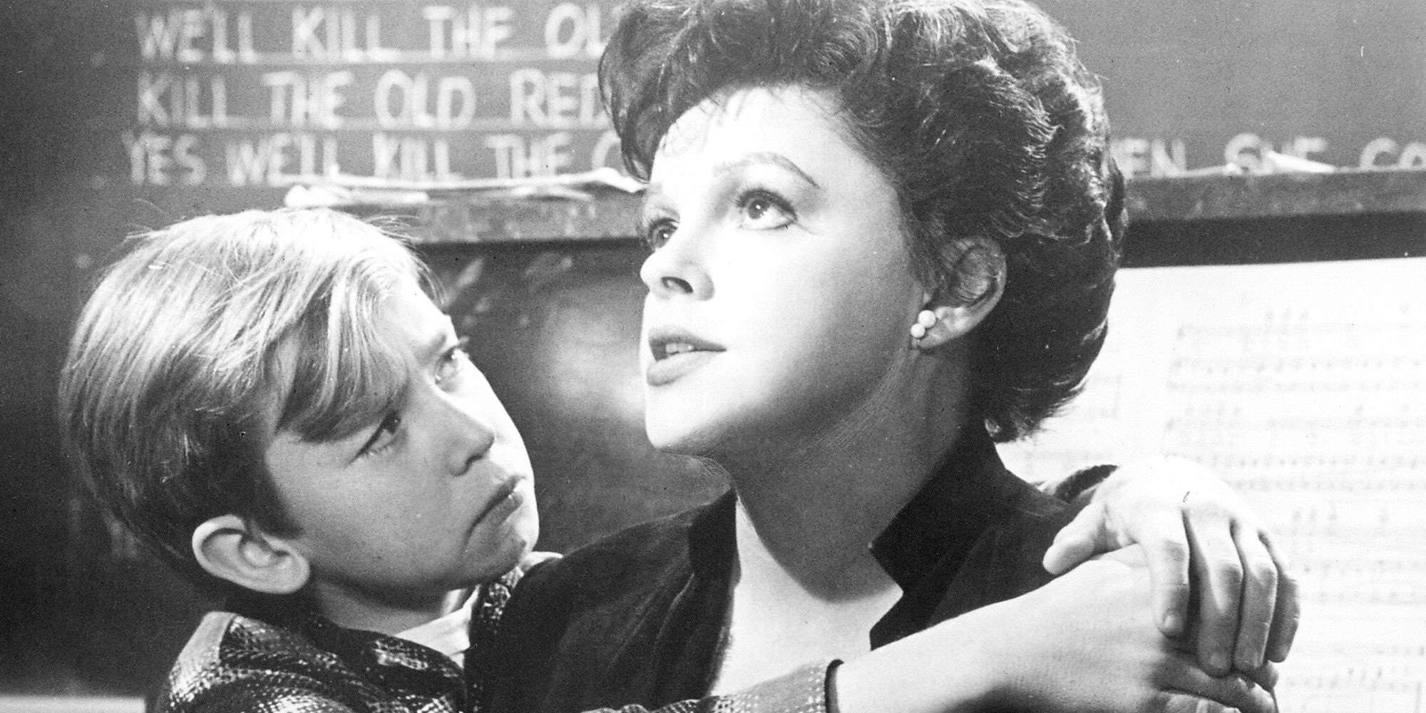 A child hangs around Judy Garland's neck