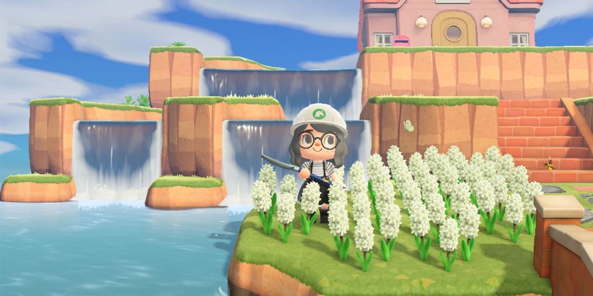 A player poses in front of a terraformed water feature.