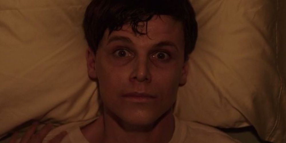 Arnes opens his eyes wide while lying in a hospital bed in The Conjuring The Devil Made Me Do It