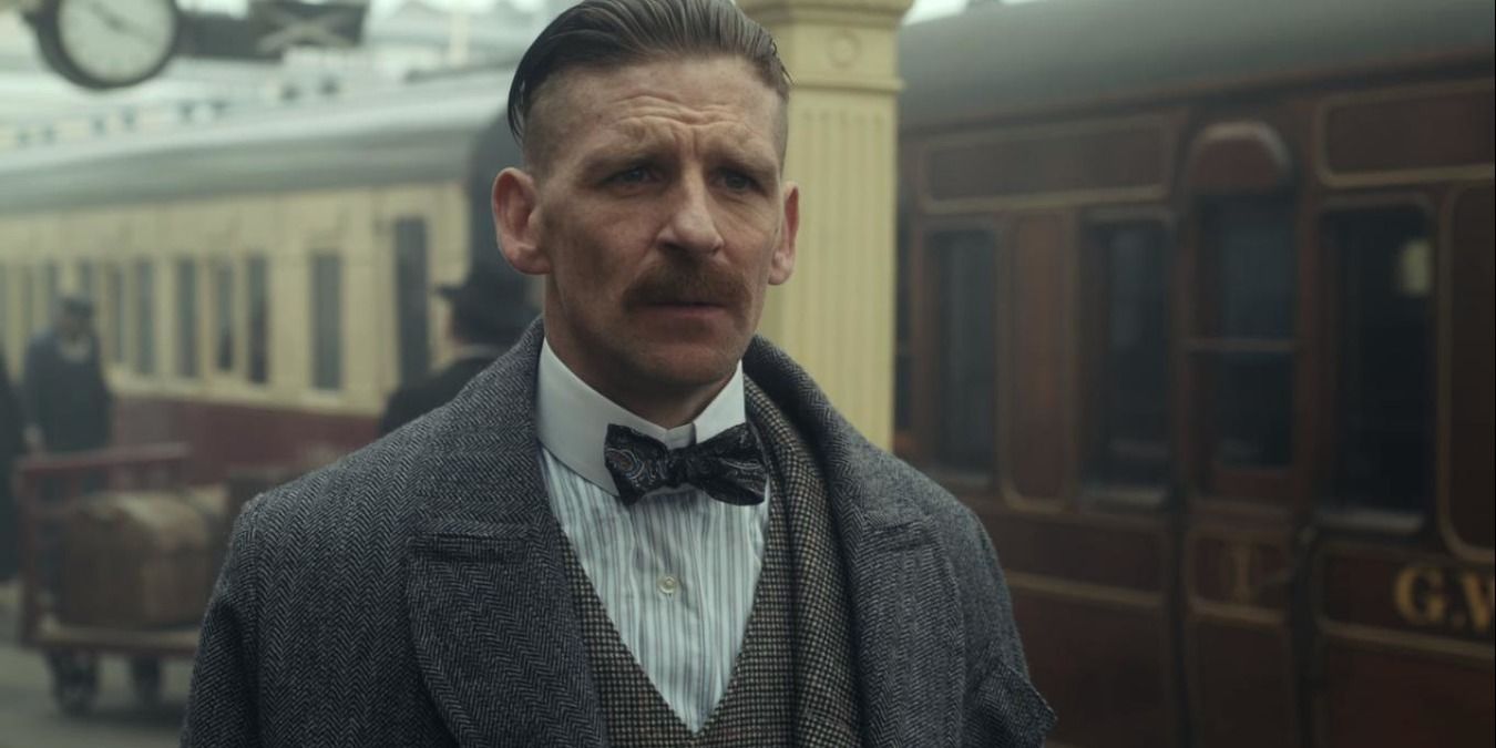 Arthur standing by the train station in Peaky Blinders