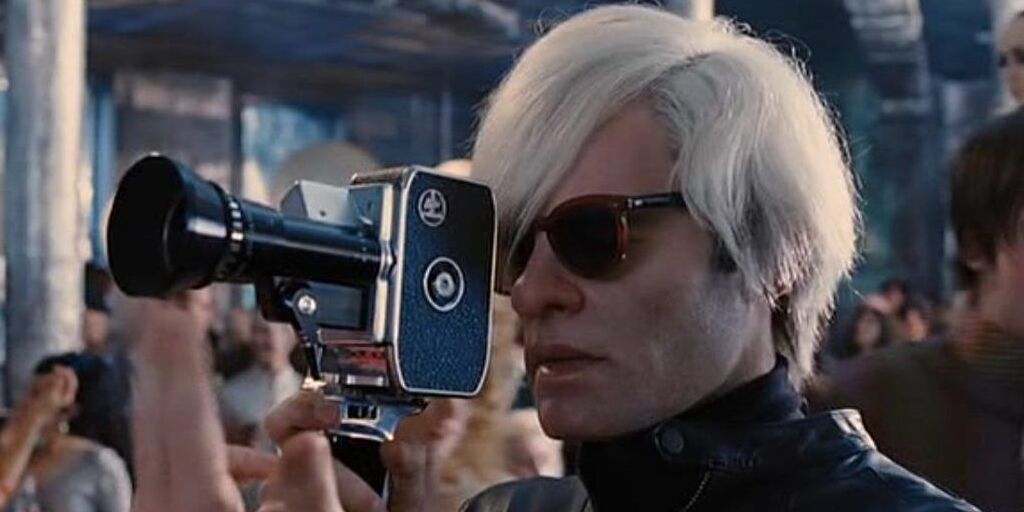 Andy Warhol looks into a camera